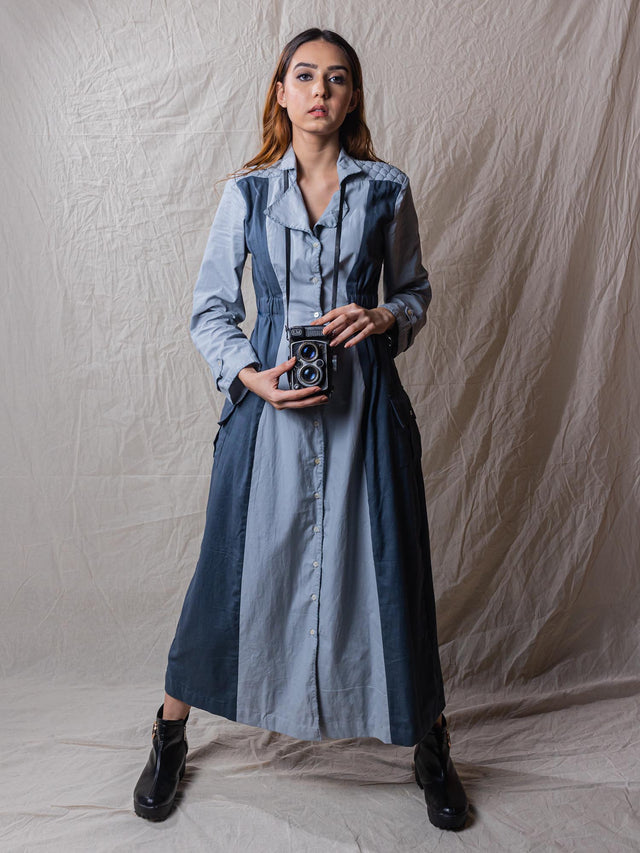 Waddle is a trench dress, cinched around waist, with pockets, embroidered back, power shoulders, button down, detail of buttons on sleeves