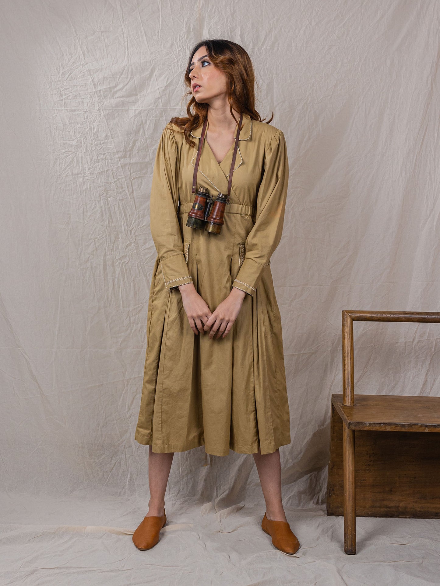 trench dress, cinched around waist, with pockets, puff sleeves with power shoulders, overlap front, detail of buttons on sleeves with embroidery