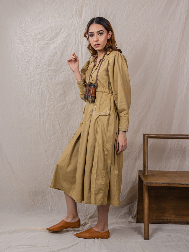 trench dress, cinched around waist, with pockets, puff sleeves with power shoulders, overlap front, detail of buttons on sleeves with embroidery