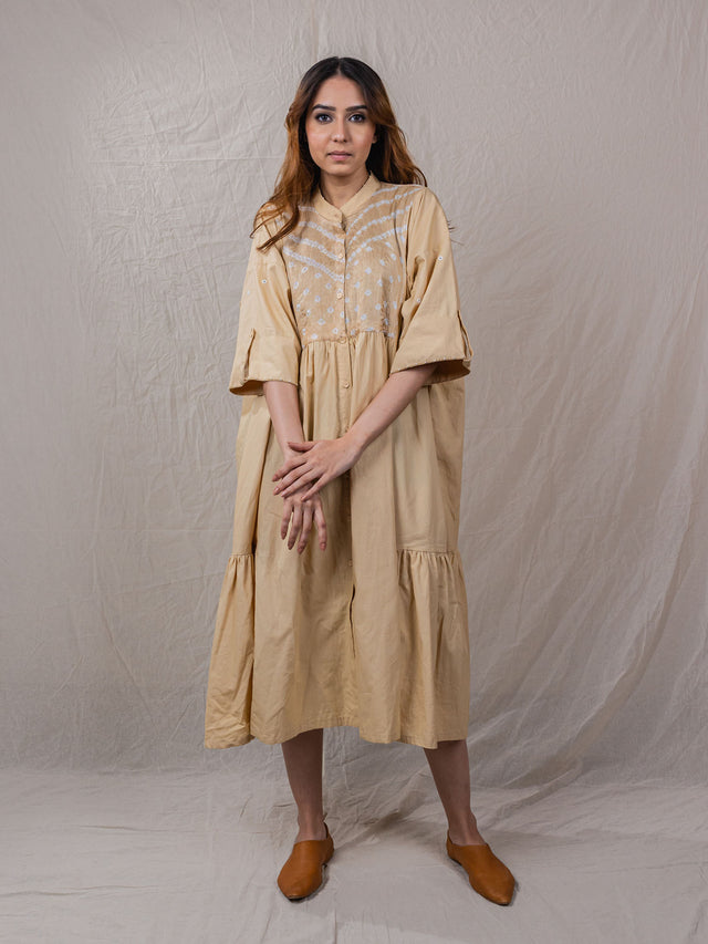 button down cotton dress jacket with elbow length sleeves and handwork details. oatmeal brown colour. could be used as a dress or a jacket.
