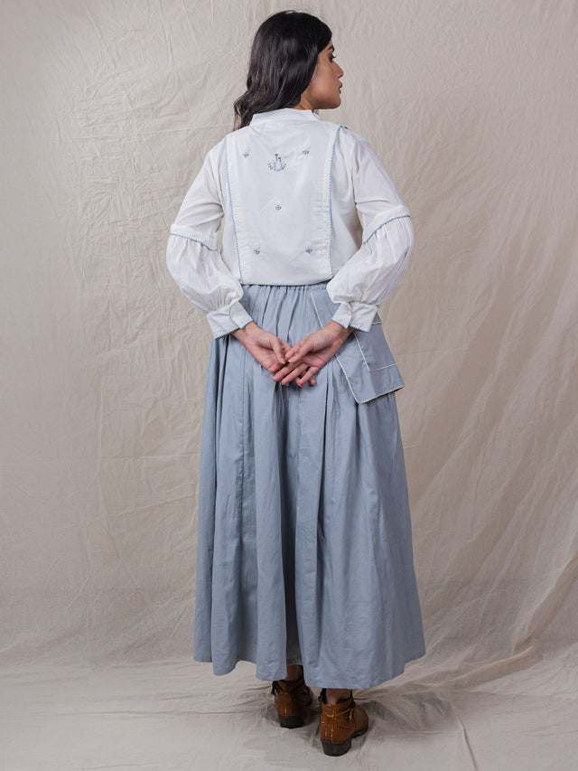 two piece set of top and skirt made from cotton fabric with intricate details of hand embroidery in the front panel of top and sleeve hem, the skirt is pleated from one side and flap from other which has a big pocket on it